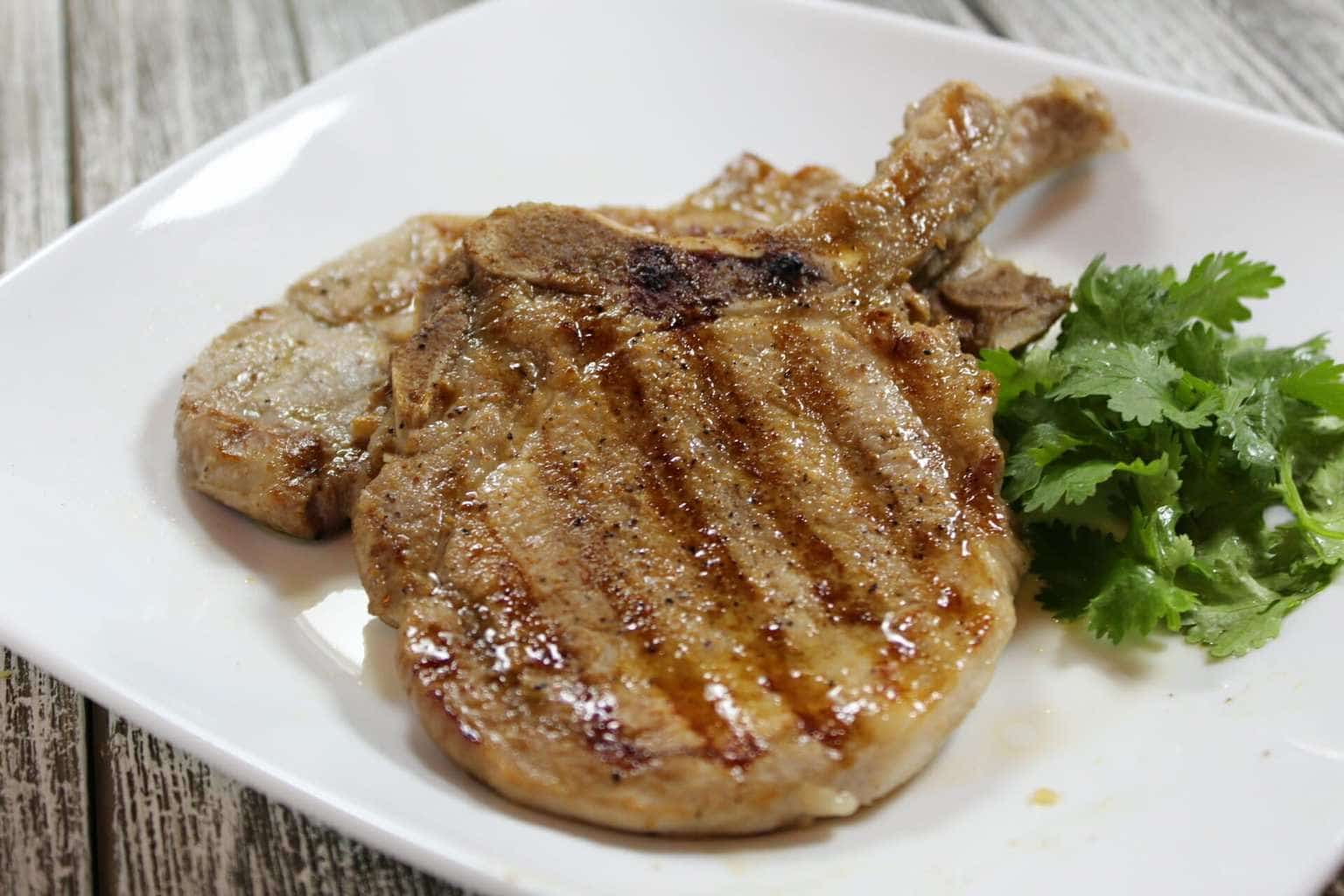 Grilled pork chops on a white plate