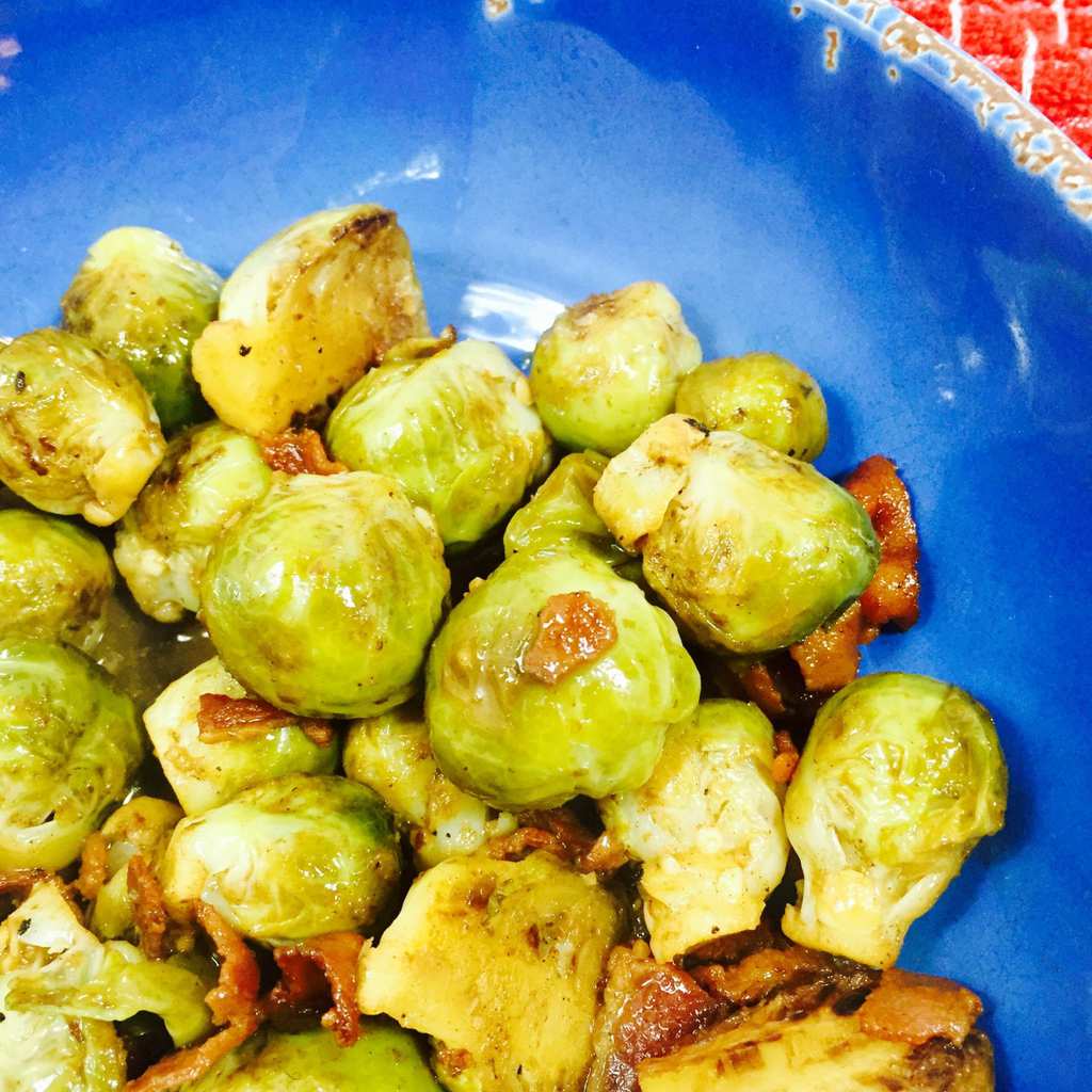 Cooked Brussels sprouts with bacon in a blue bowl