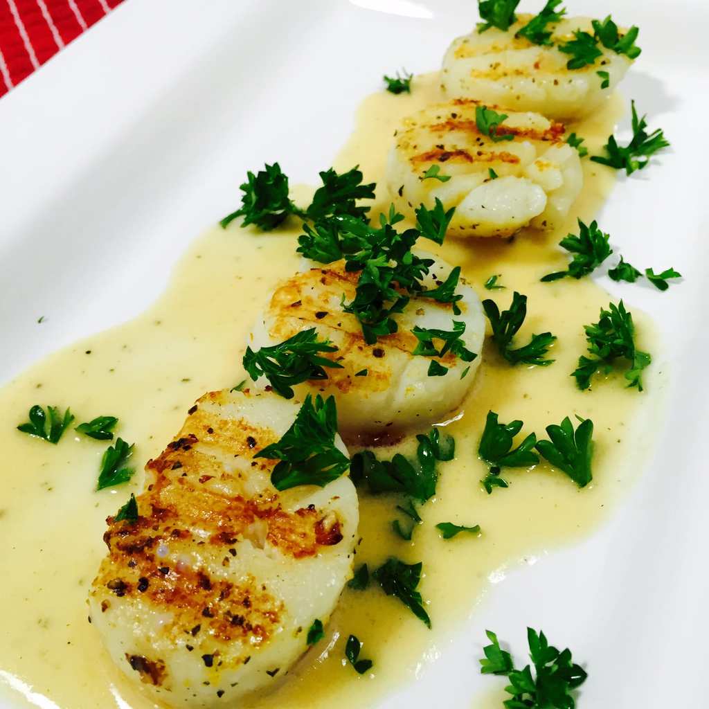 Seared Scallops on a plate of lemon butter sauce