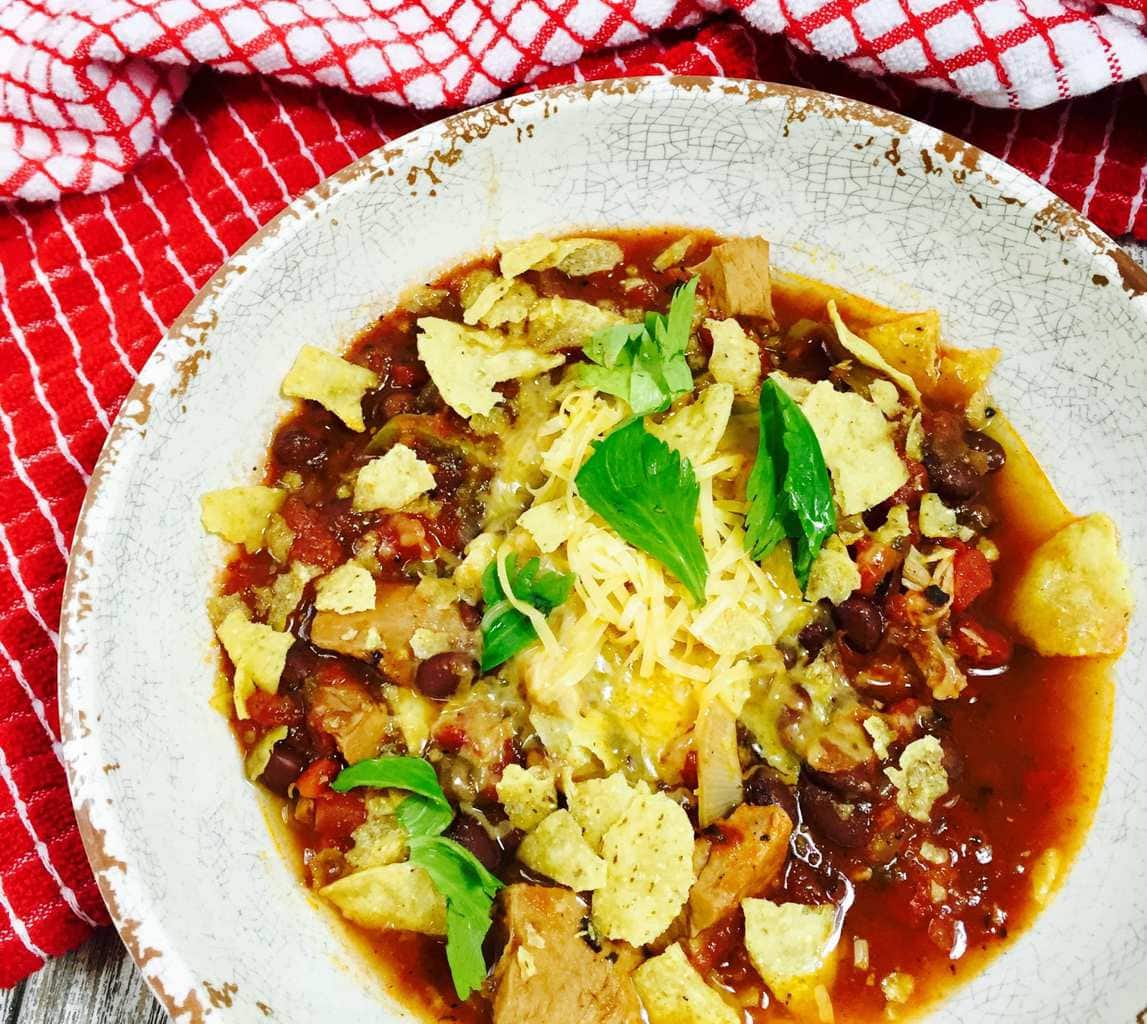 Pork Chile with tortillas and cheese on a white plate