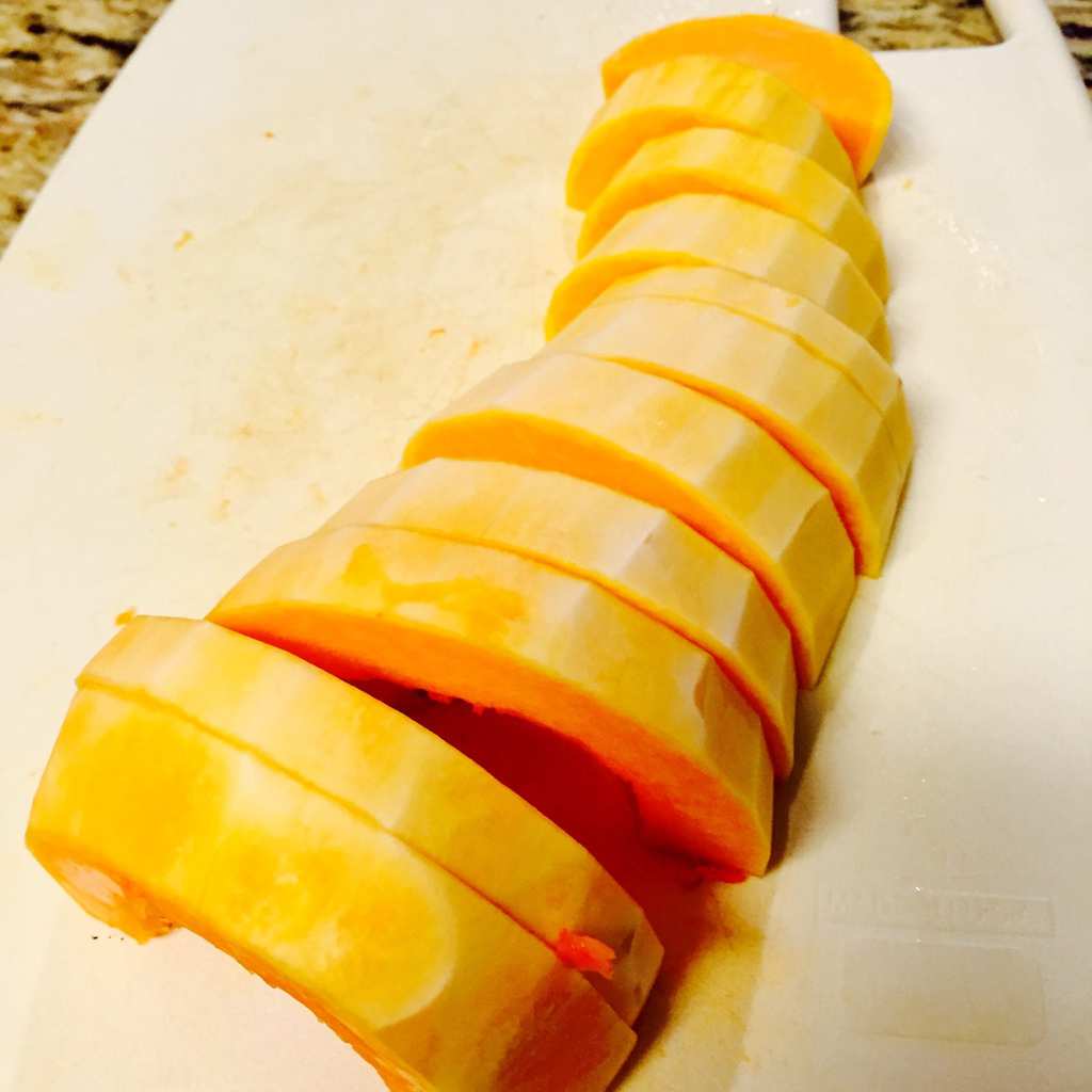 Sliced butternut squash on a white cutting board