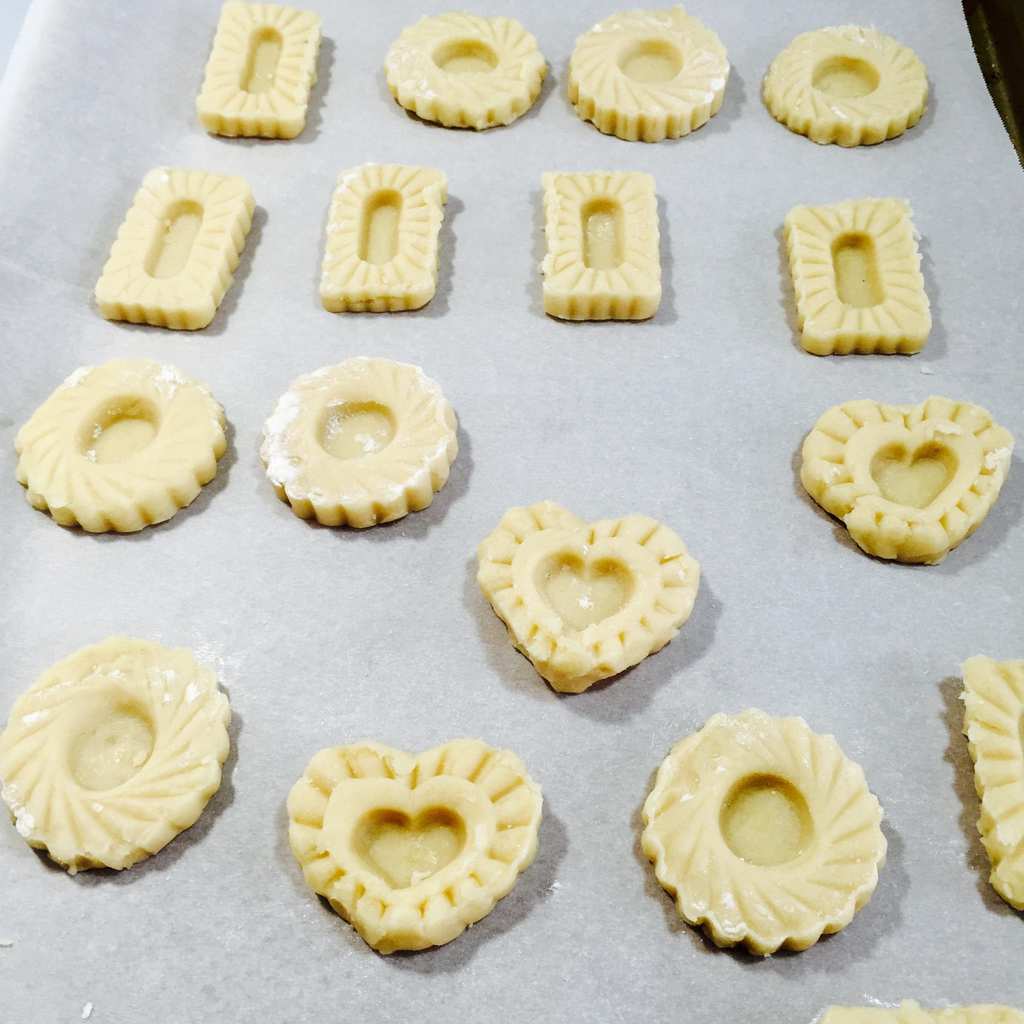 cutting out cookies with a heart shaped stamp