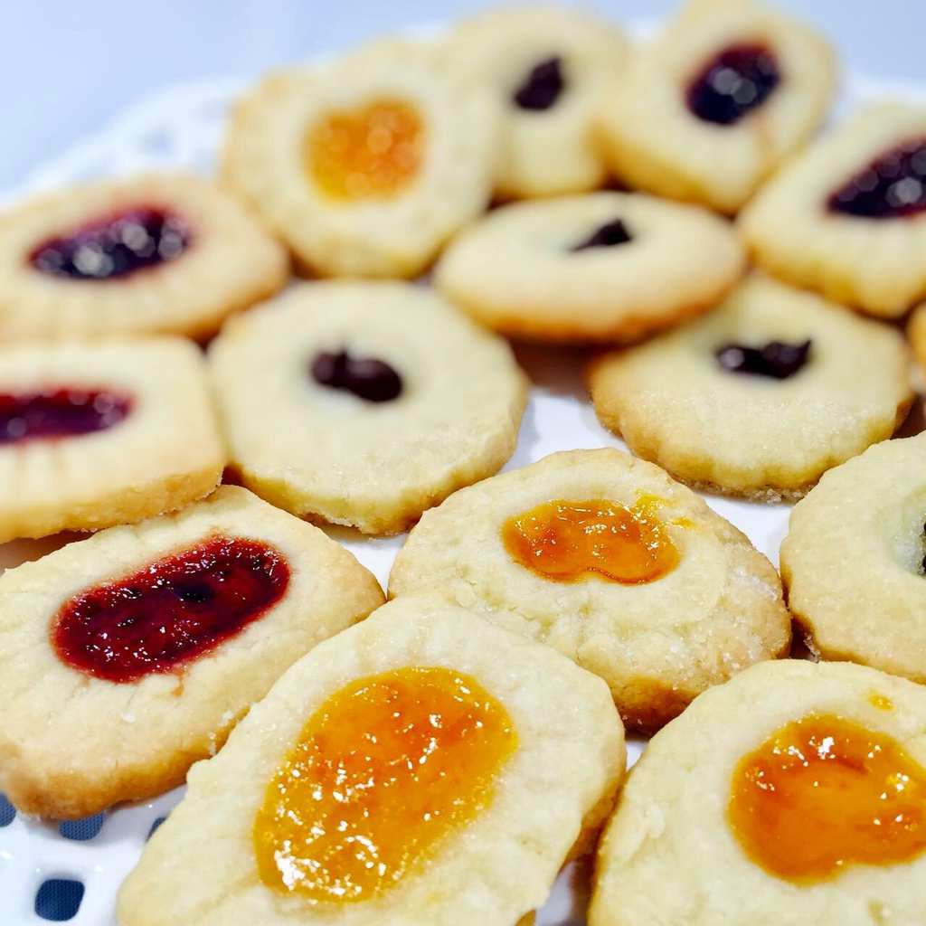 Jam filled shortbread cookies on a white plate