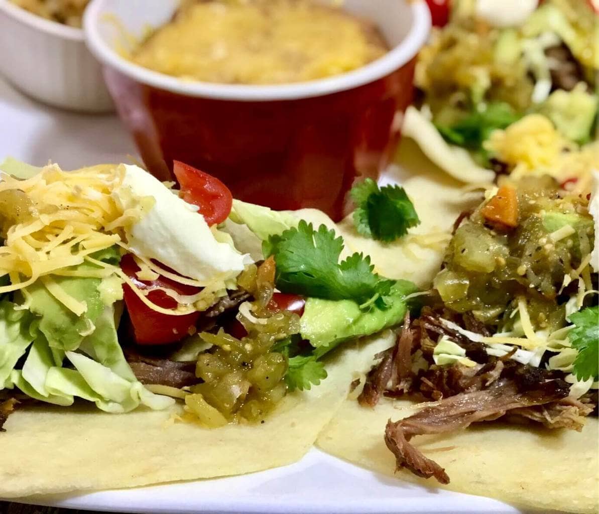 brisket tacos on a white plate