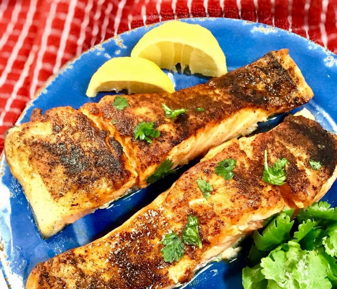 baked salmon on a blue plate with lemon